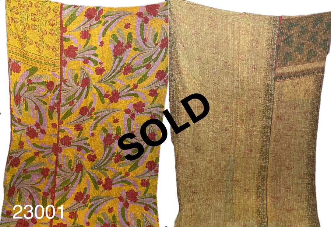 Two colorful Kantha Quilts are displayed. The left quilt features a floral pattern on a yellow background, while the right one has a more subdued design. The word "SOLD" is overlaid in black. Number "23001" is in the lower left corner.