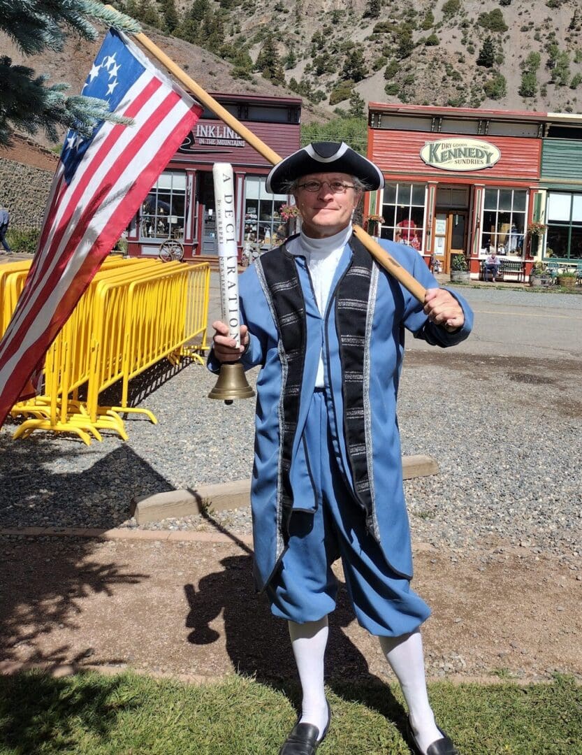 A man in costume holding an american flag.