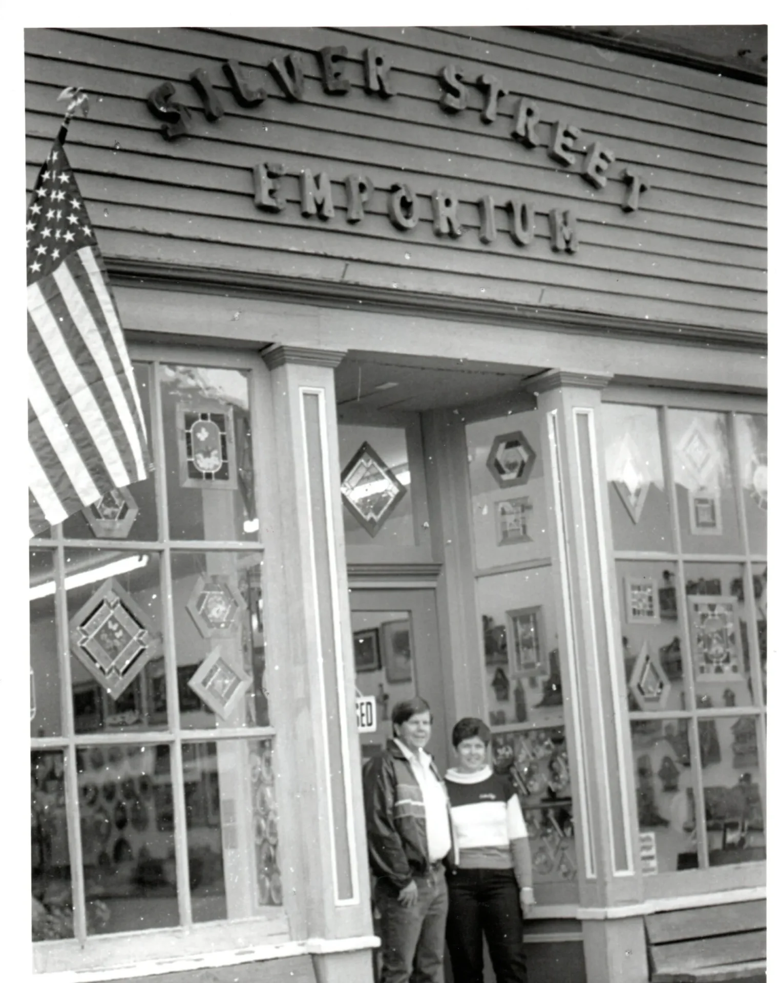 A man and woman standing outside of a store.