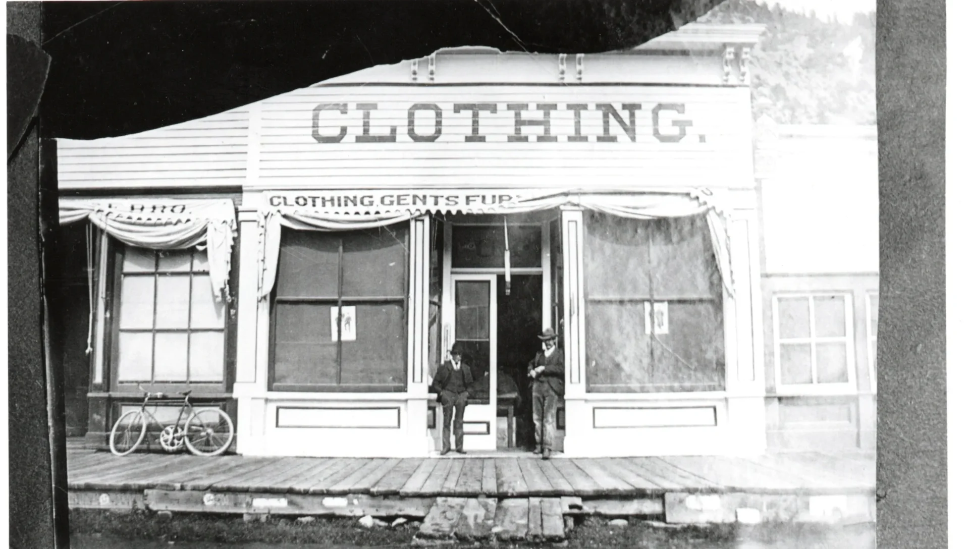 A man standing outside of a clothing store.